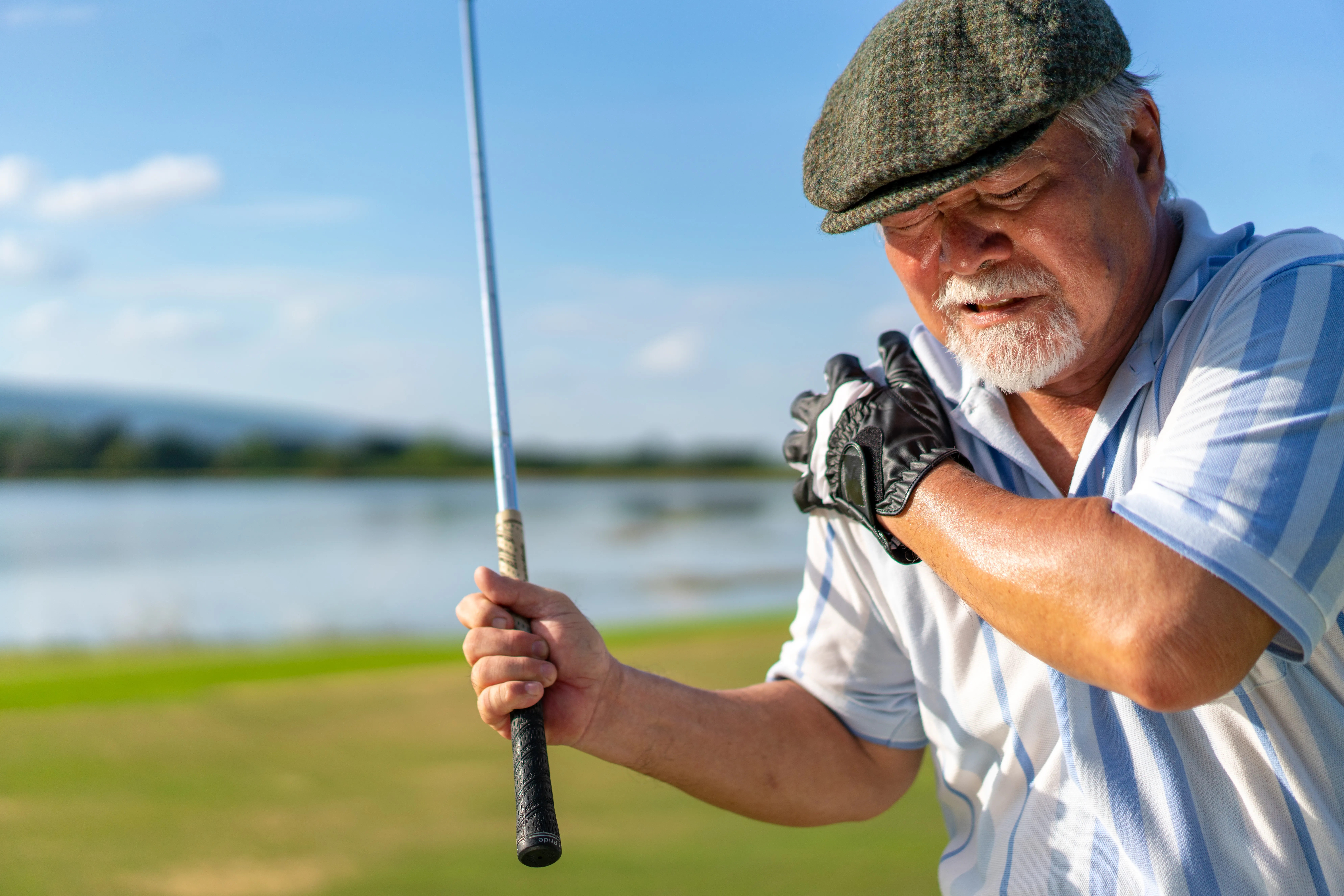 Golfer holding shoulder with arthritis.
